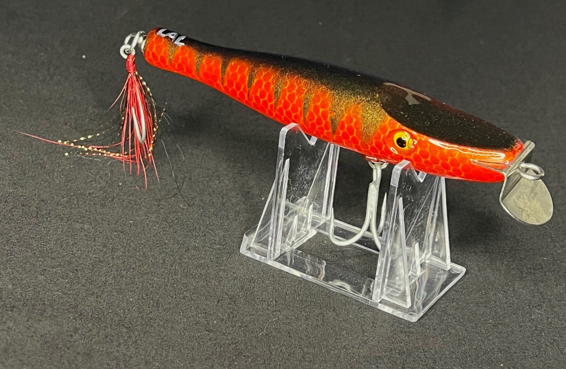 Metal lipped wood bait painted Red with a black stripe